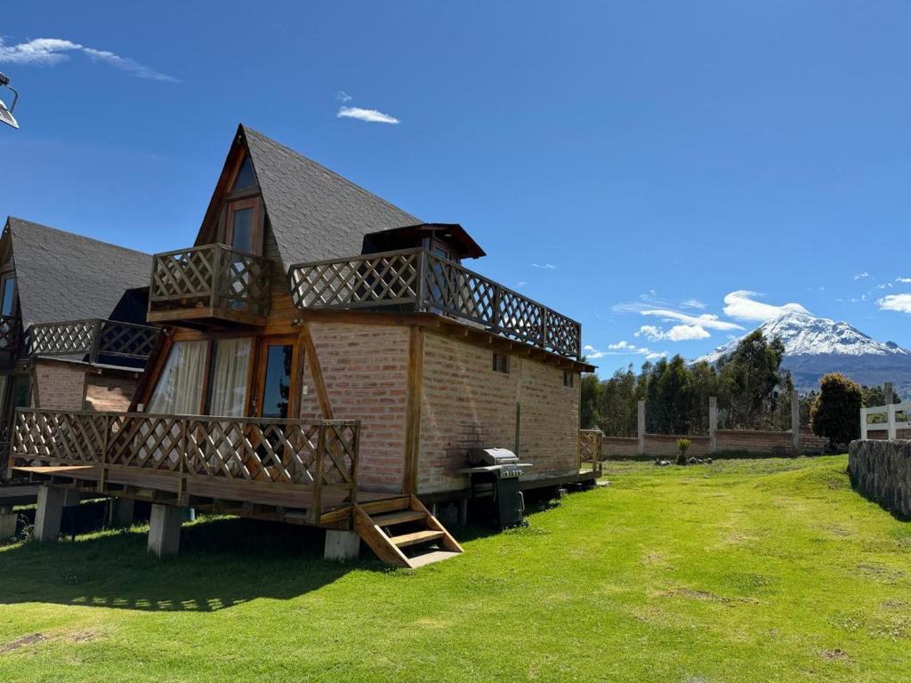 a house with a deck and mountains in the background at Mount House Lodge in Guano