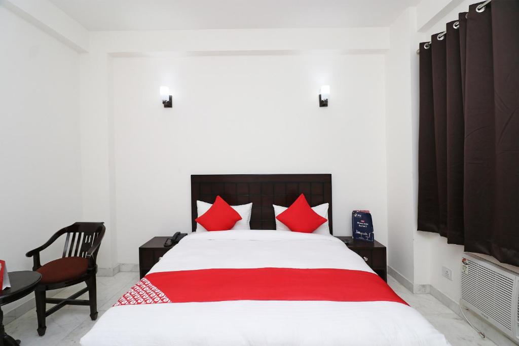 a bedroom with a large bed with red pillows at Hotel O The Primero Near Leisure Valley Park in Gurgaon