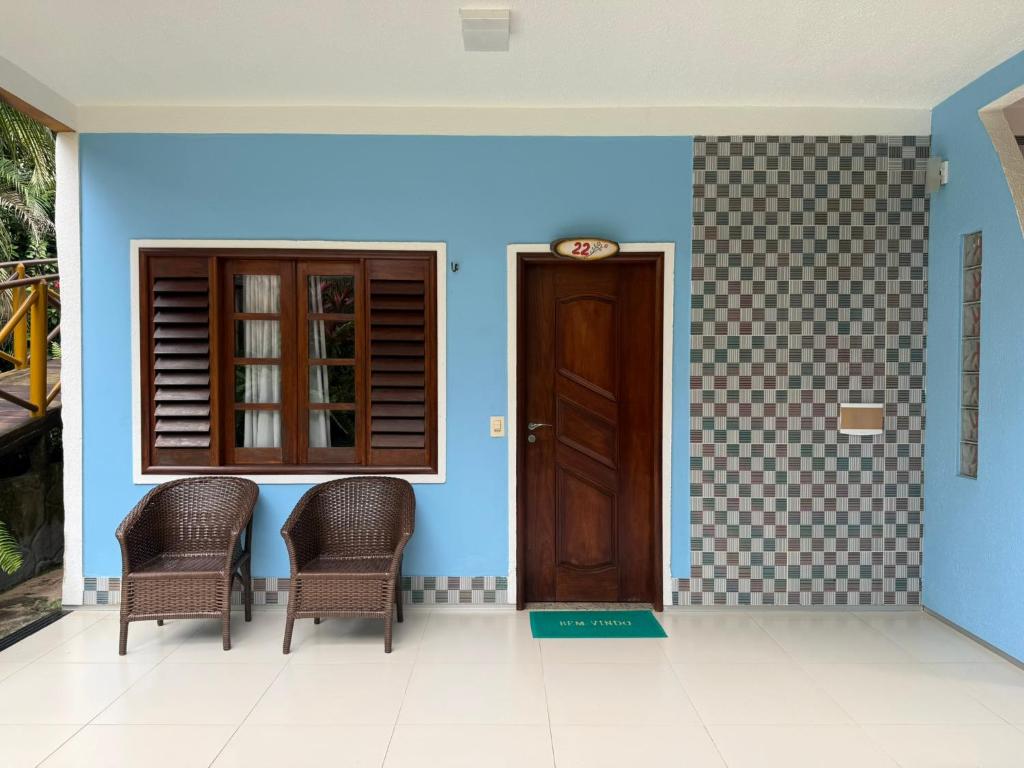 a front door of a house with two chairs at Pousada Pedra Grande in Morros