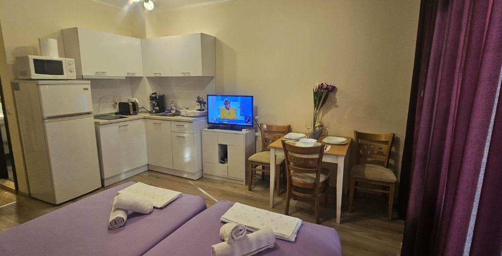 a small kitchen with a table with a laptop on it at Sun Sea 2 in Shkorpilovtsi