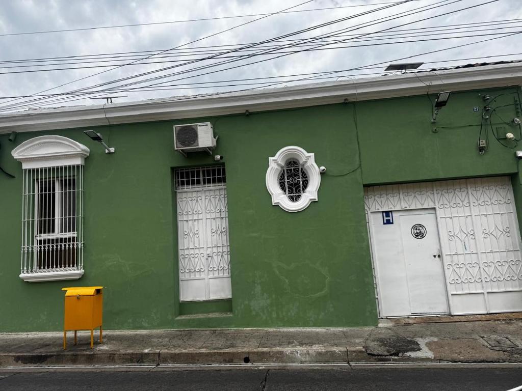 a green building with a window on the side of it at Hostal Casa Verde in Santa Ana
