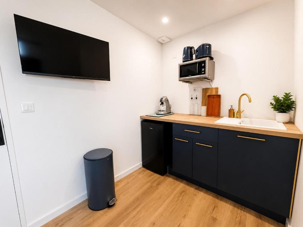 a small kitchen with a sink and a microwave at Azur, Cosy Blue studio, ultra centre de Desvres in Desvres