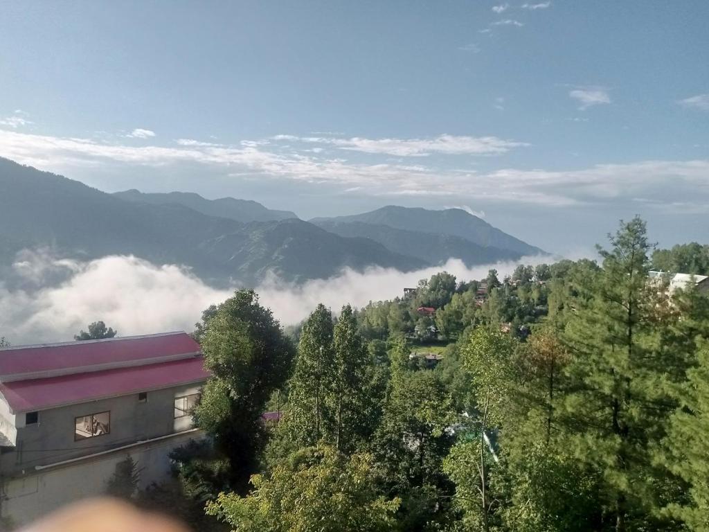 a view of a valley with clouds and mountains at BHURBAN MOUNTAIN VIEW APARTMENTs in Murree