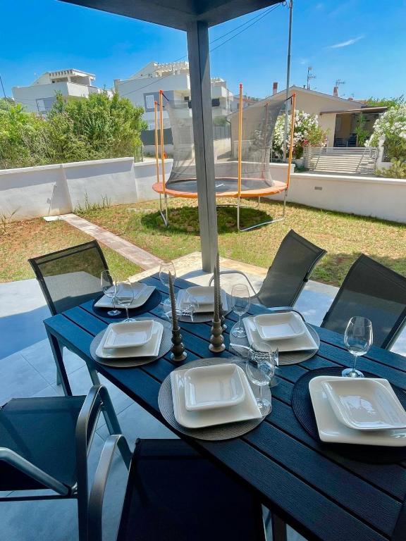 a blue table with plates and glasses and an umbrella at Villa Ivana in Peroj