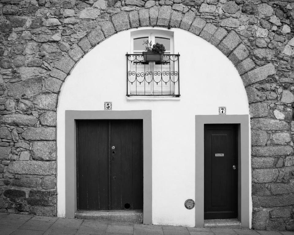 two doors on the side of a stone building at Ductus Aquae House in Évora