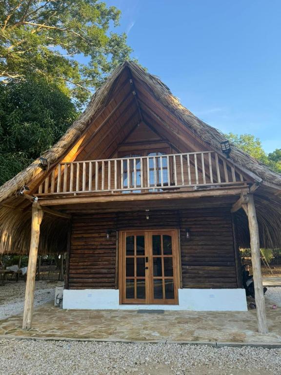 a small wooden house with a thatched roof at Cabaña Vivanco in Coveñitas