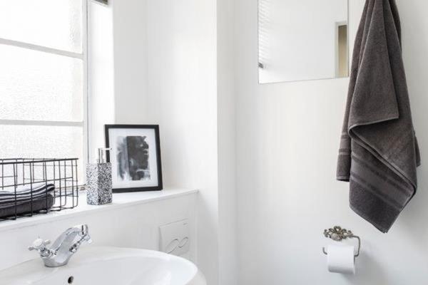 a white bathroom with a sink and a window at Stylish 1BR in Durban