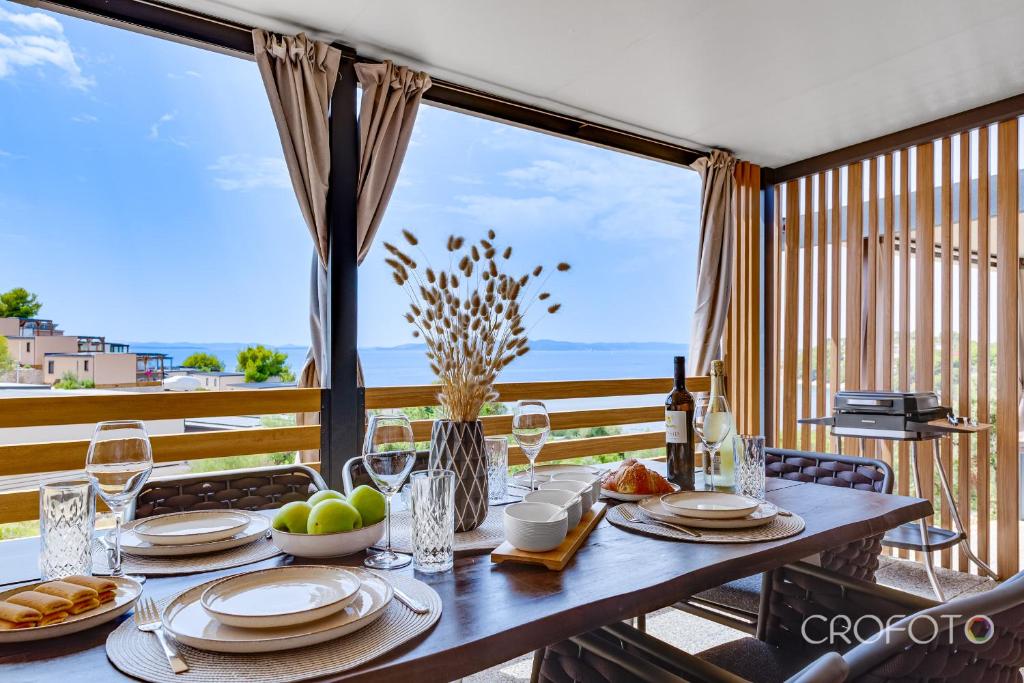 a dining table with a view of the ocean at Mobile Home Altura Luxury Sea View Retreat in Drage