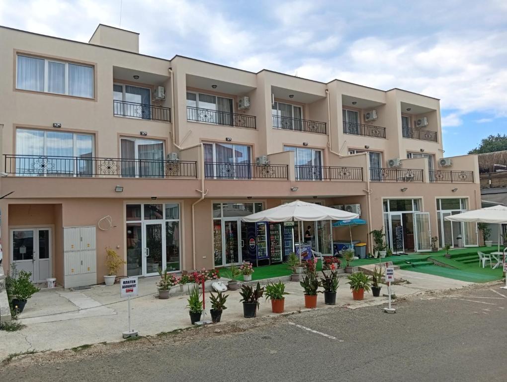 a large apartment building with umbrellas in front of it at Kristan in Sveti Vlas