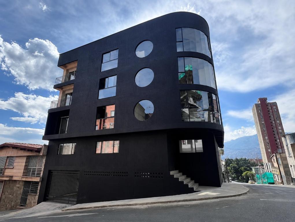 a black building with circular windows on a street at Hotel Moore 45 in Medellín