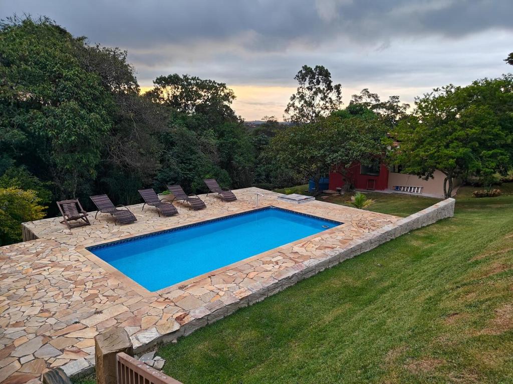 a swimming pool in a yard with lounge chairs at Cura e Conexões in Jarinu