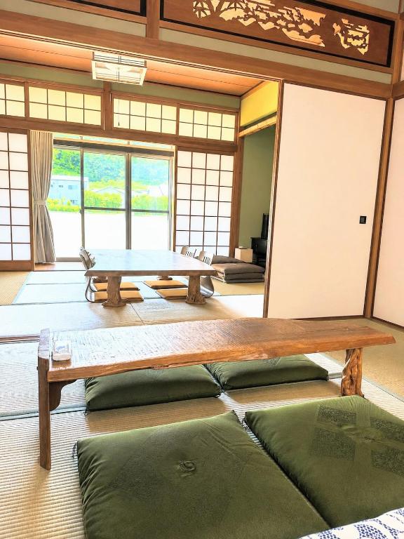 a room with a table and some green pillows at オリーブママのヤド 凪 バーベキュー機材レンタル可 in Shodoshima