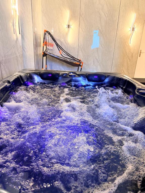 a jacuzzi tub filled with water in a room at Maison privative SPA Jacuzzi Sauna Salle de jeux in Weitbruch