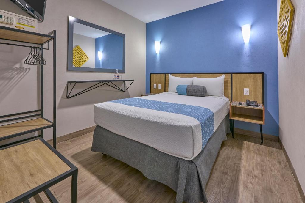 ein Schlafzimmer mit einem großen Bett und einer blauen Wand in der Unterkunft Continental Mexicano in Mexiko-Stadt