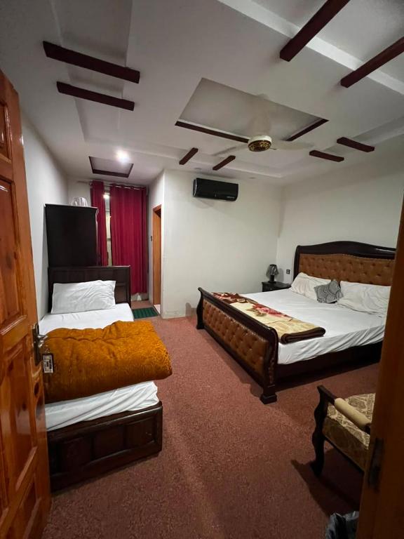 a hotel room with two beds and a couch at Pine View Hotel Tranna Balakot in Taranna