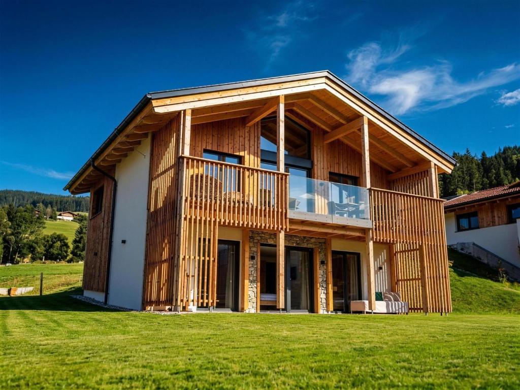 a wooden house on a hill with a green lawn at Grebenzen 66 in Sankt Lambrecht