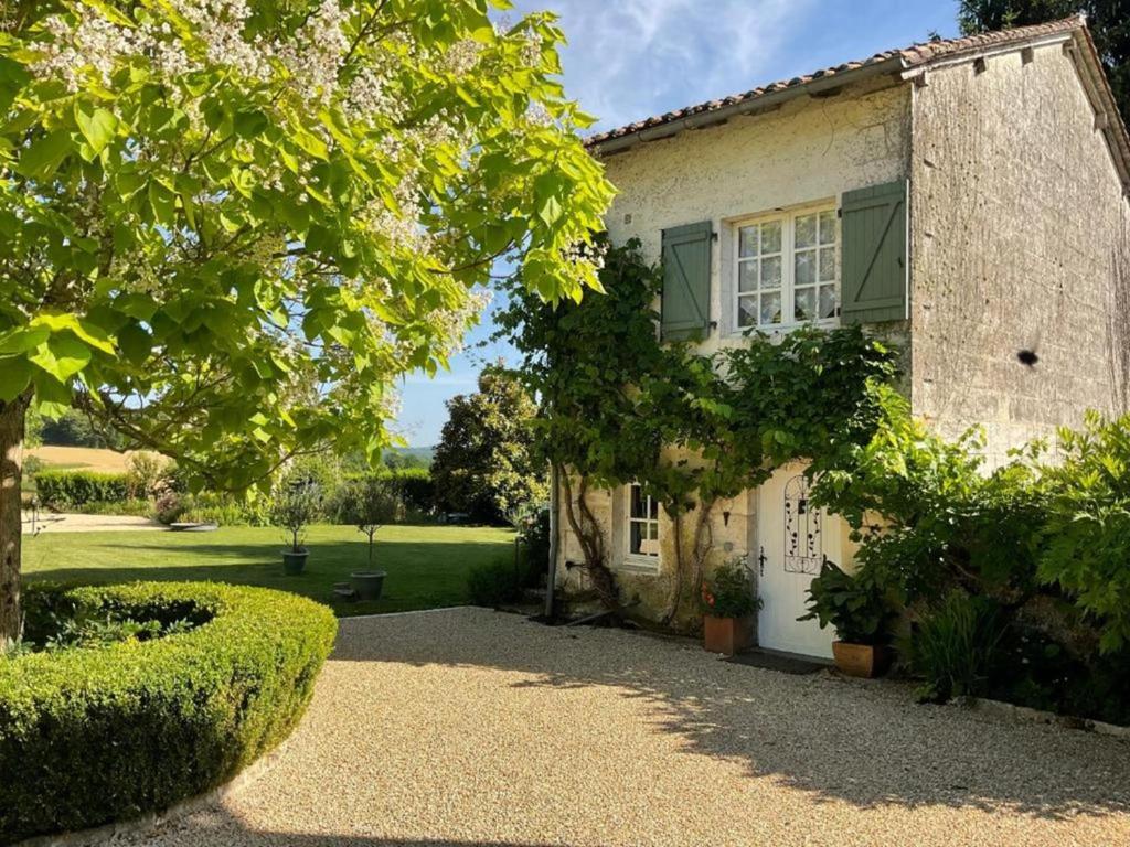 a house with a tree and a gravel driveway at Petit Vingne in Édon