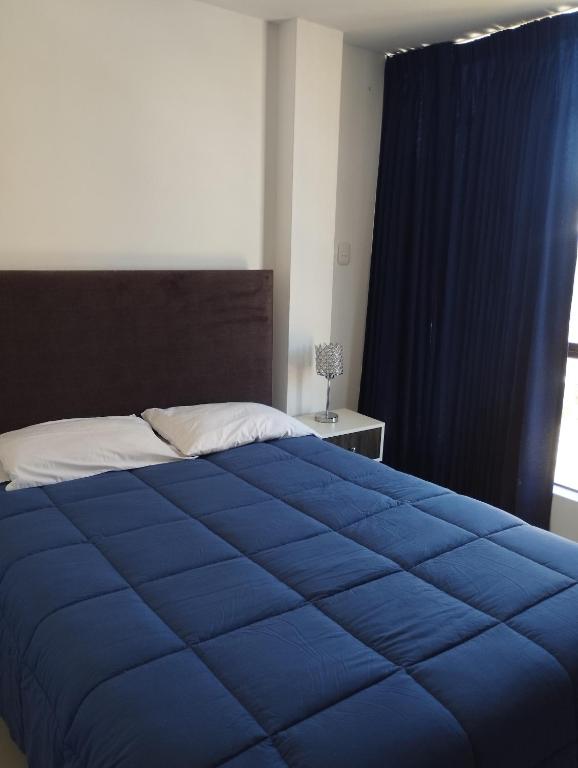 a bedroom with a blue bed with a blue blanket at Alpha in Cajamarca