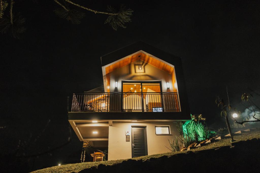 a house with a balcony on the side at night at CABANAS LE VIGNE in Pinto Bandeira