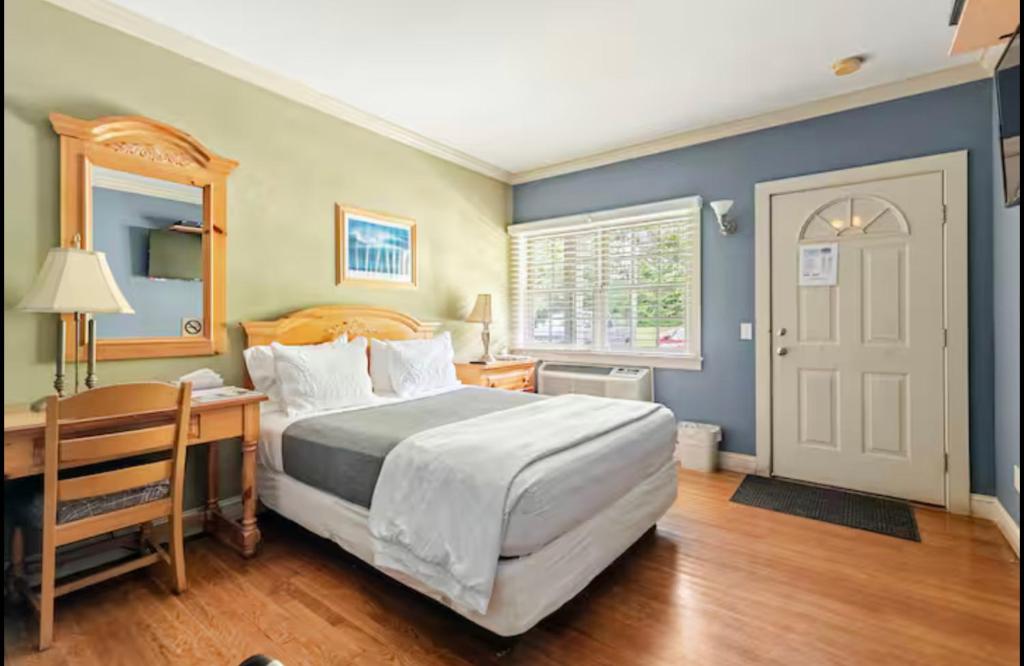 a bedroom with a bed and a desk and a door at Southampton Long Island Hotel in Southampton