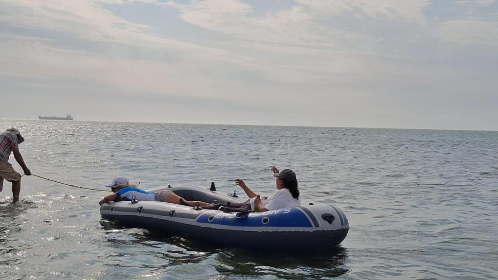 a man pulling a woman in a raft in the water at La Bahia de Makale in Pisco