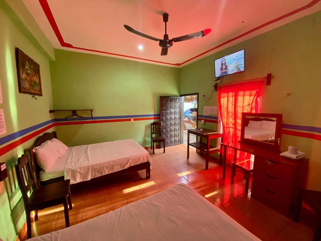 a bedroom with a bed and a desk and a television at HotelMariaAngela in Dzuiché