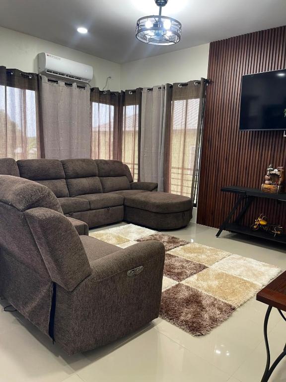 a living room with a couch and a flat screen tv at Suite Seven in Mount Pleasant