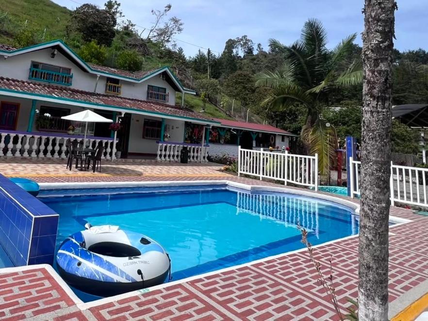 a pool with a boat in front of a house at Finca Hotel Mariangel in El Peñol