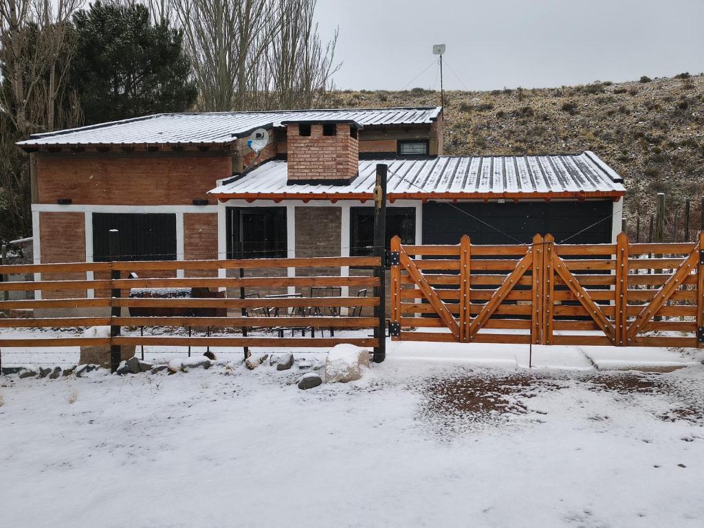 a house with a wooden fence in the snow at LC House in Potrerillos