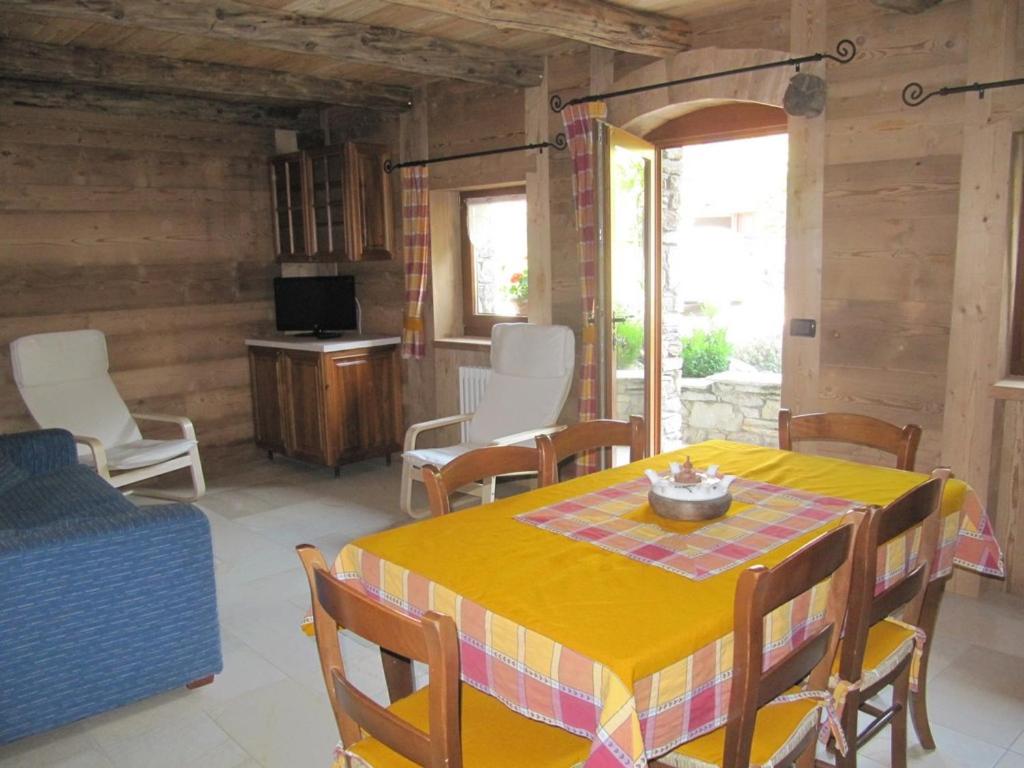 une salle à manger avec une table et des chaises jaunes dans l'établissement Appartamento Le Jardin CIR VDA Aymavilles 0009, à Aymavilles