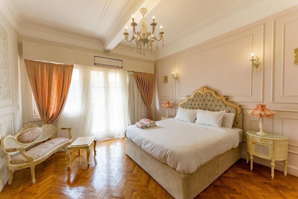 a bedroom with a large bed and a chandelier at El Otel Hotel in Cairo
