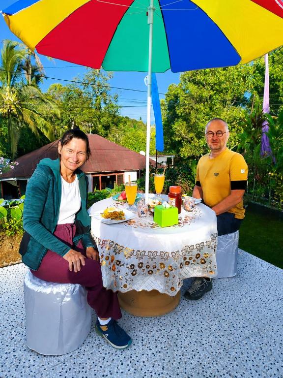a man and a woman sitting at a table under an umbrella at Gosela Bali in Munduk
