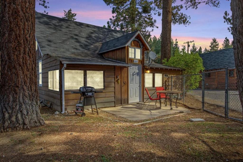 a small cabin with a grill and a table at Bear Sky Cabin in Big Bear City