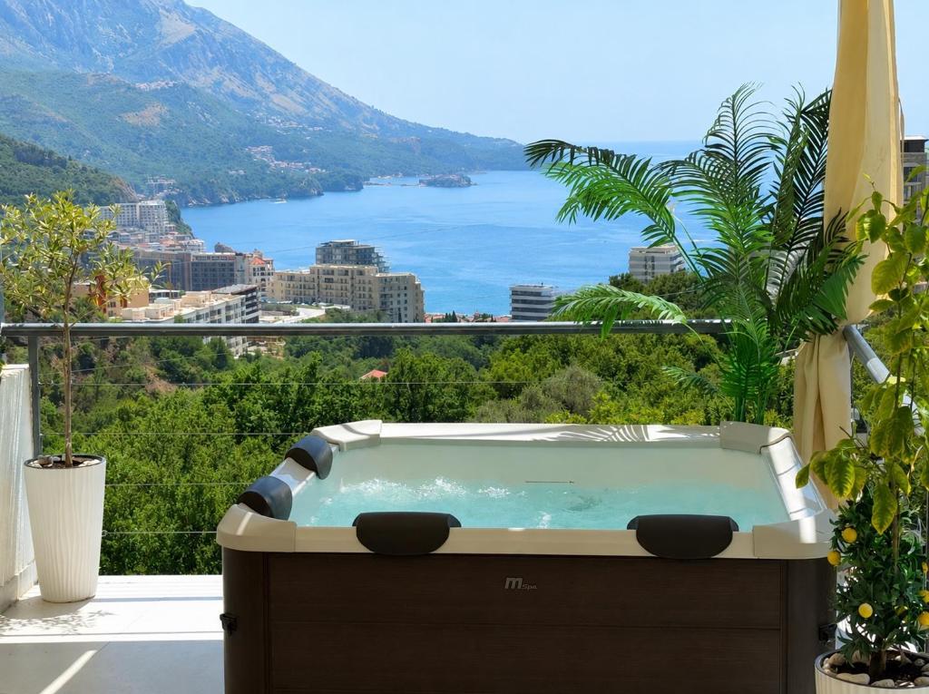a hot tub on a balcony with a view of the ocean at Apartman Marija sa ličnim đakuzijem in Bečići
