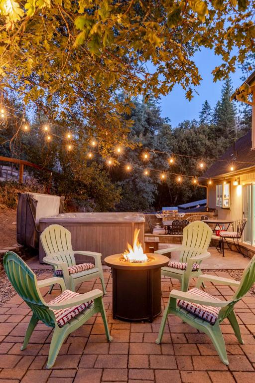 a patio with chairs and a table and a fire pit at Peaceful Chalet in Oakhurst
