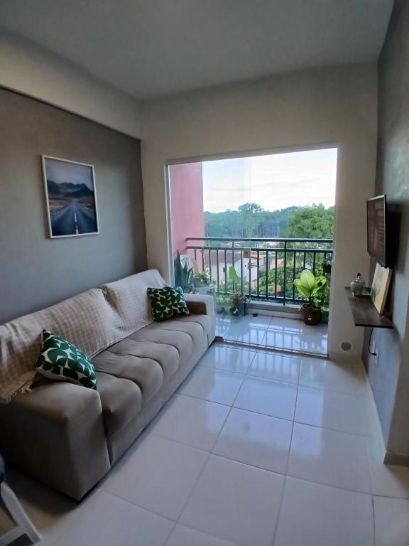 a living room with a couch and a balcony at Apartamento Completo com piscina e play infantil in Ananindeua