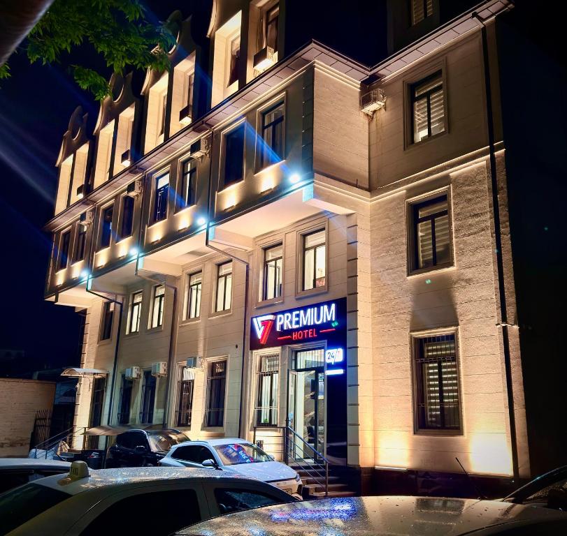 a building with a neon sign in front of it at Premium Yunusobod Hotel in Darkhon