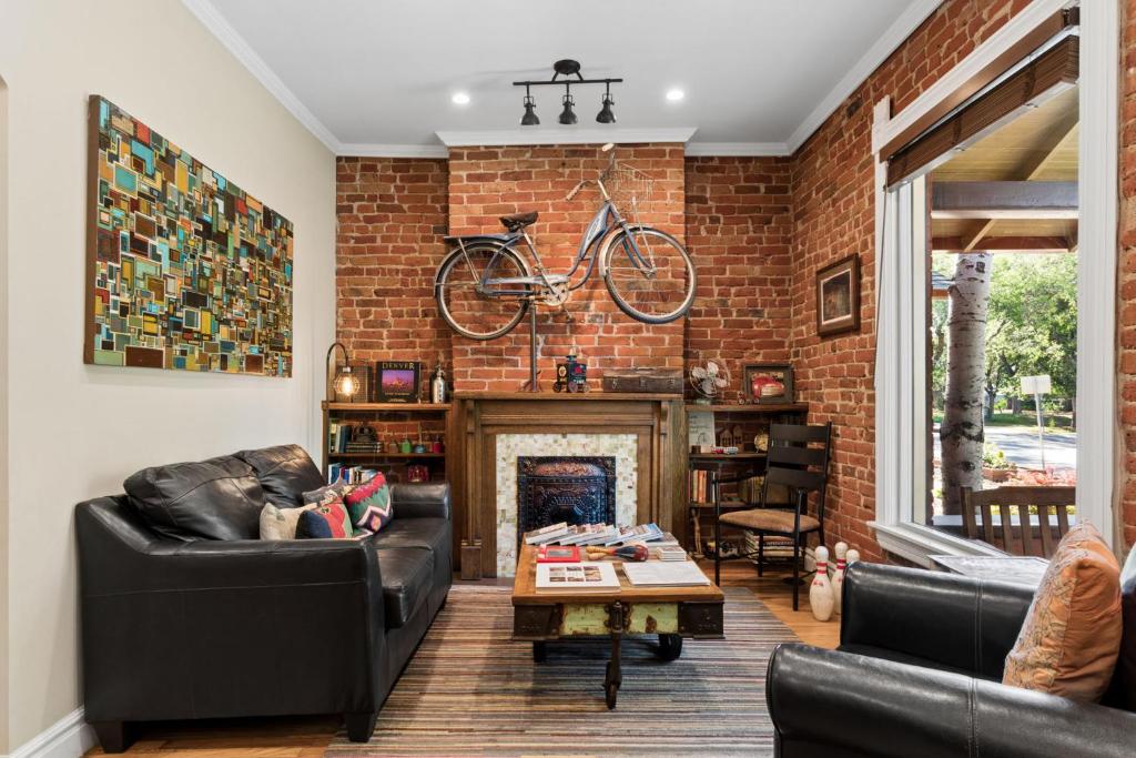 a living room with a bike hanging on a brick wall at The Whittier Wonder in Denver