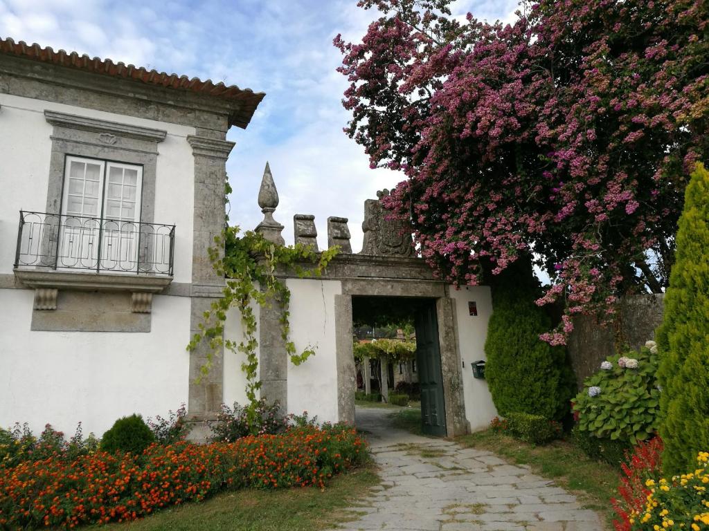 an entrance to a white house with flowers at Paco d'Anha in Viana do Castelo