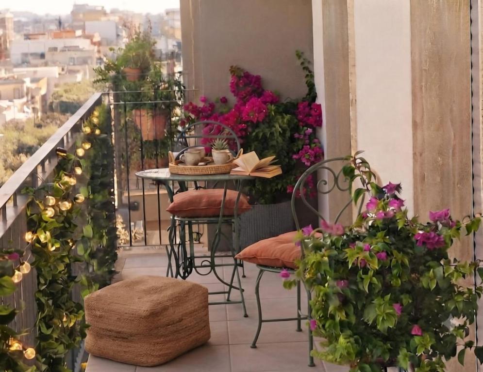 a balcony with a table and chairs and flowers at Simohouse Lecce - Executive Suite Apartment 140mq - 2 Bathrooms in Lecce