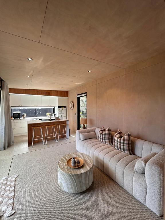 a living room with a couch and a coffee table at Cooks Beach Studio Escape in Cooks Beach