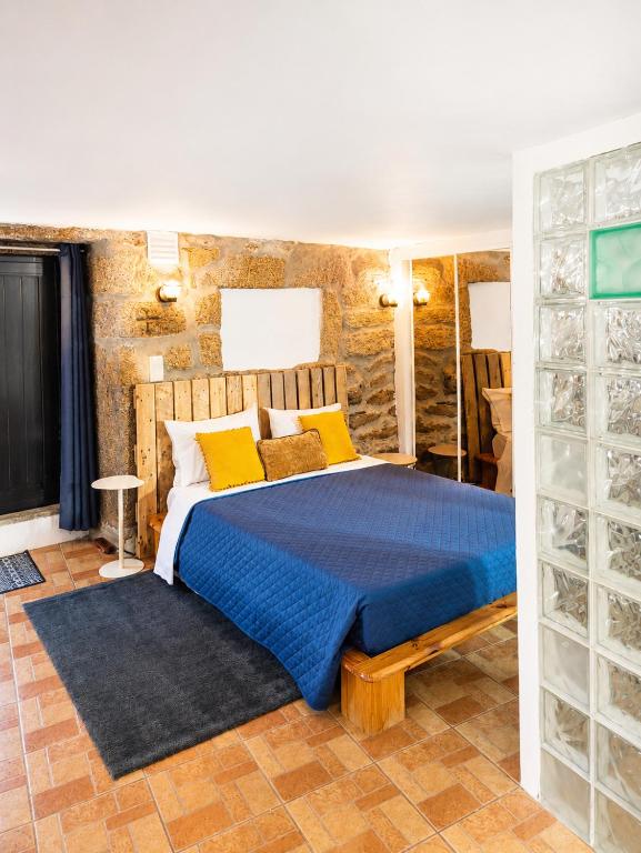 a bedroom with a blue bed with yellow pillows at Casa Aninhas in Sabrosa