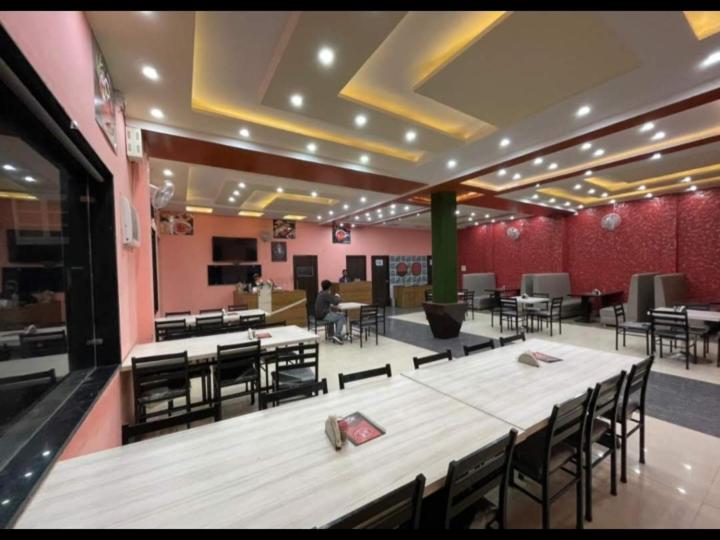 a restaurant with tables and chairs in a room at Eighty eight restaurant and cafe in Muzaffarnagar