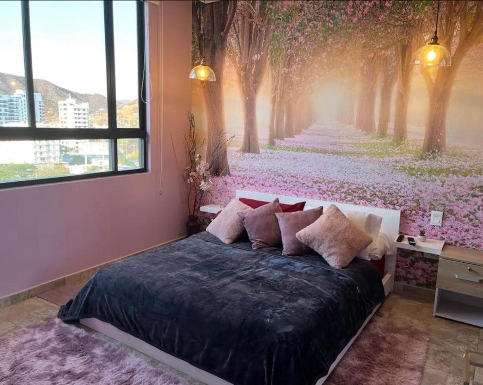 a bedroom with a bed with a painting of trees at Nuevo SMART-HOME de Lujo a Playa Rodadero con Piscina Panorámica in Gaira