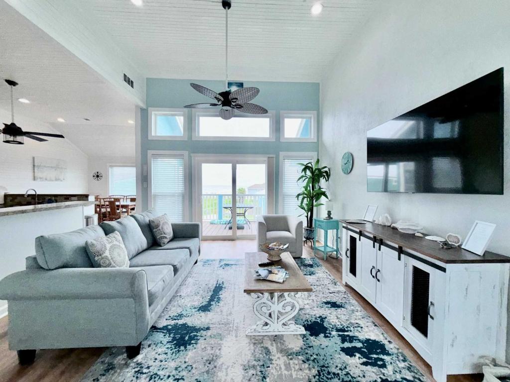 a living room with a couch and a tv at Sandy Beach Retreat and Gulf View in Galveston