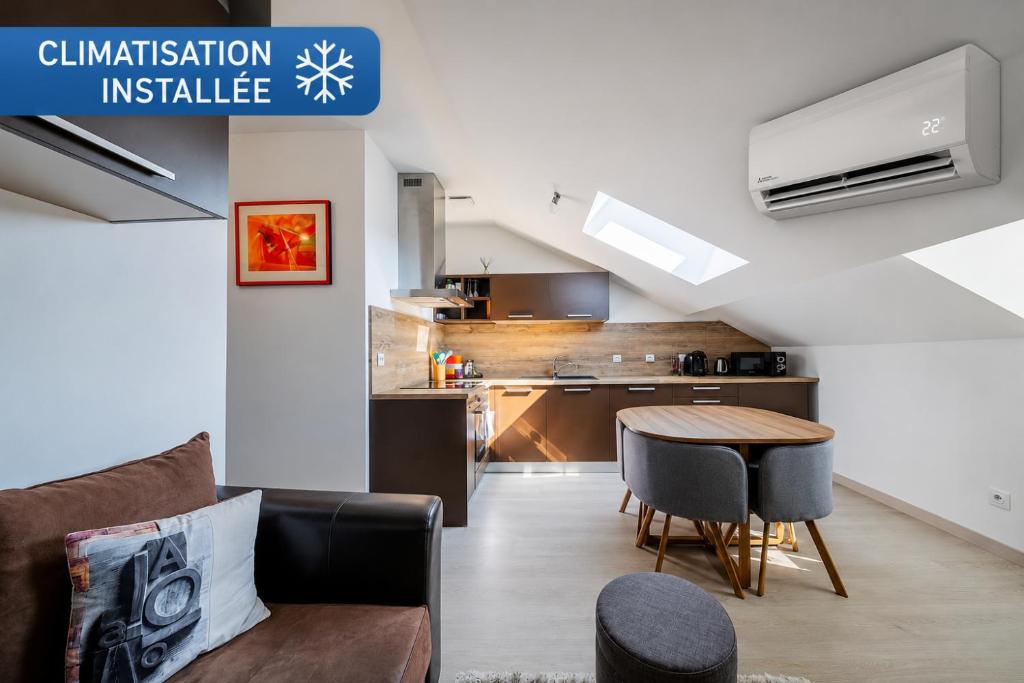 a living room with a couch and a table and a kitchen at le cocon voironnais in Rives