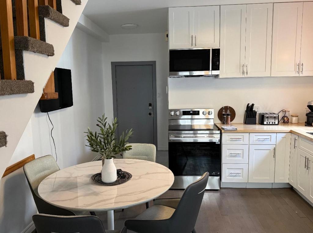 a kitchen with a table and chairs in a room at La Pergola-6 in Quebec City