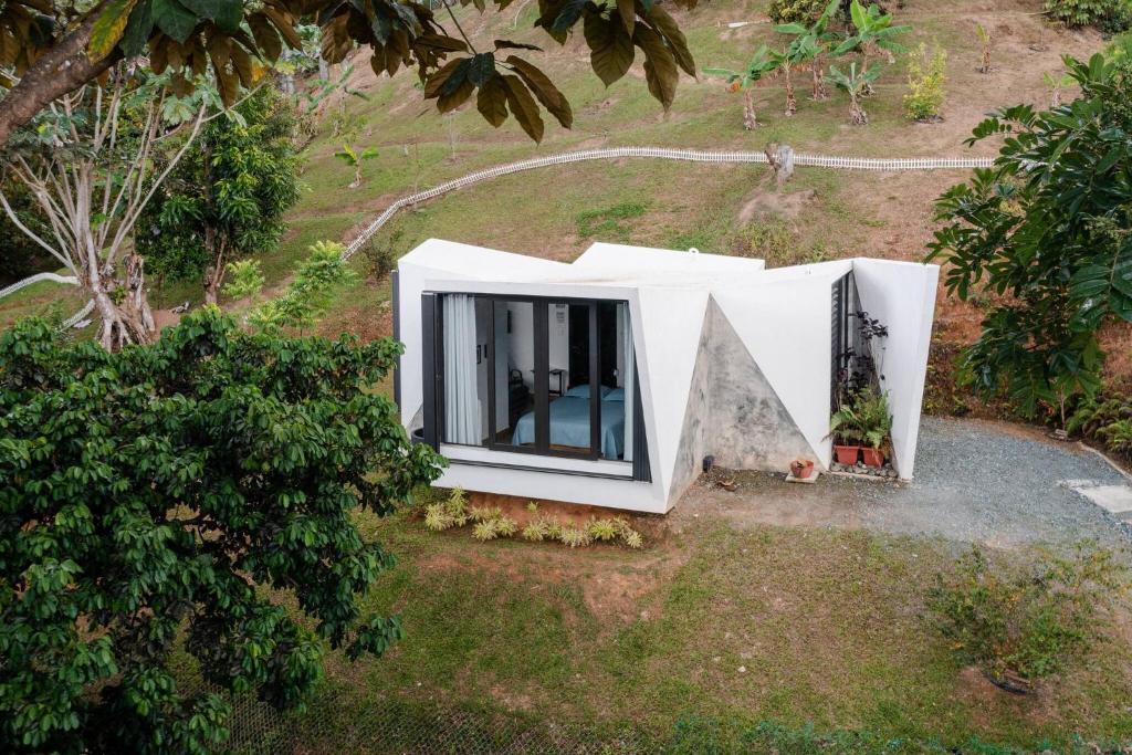 an aerial view of a white house with a pyramid at Farm Suite Bienteveo in Naranjito
