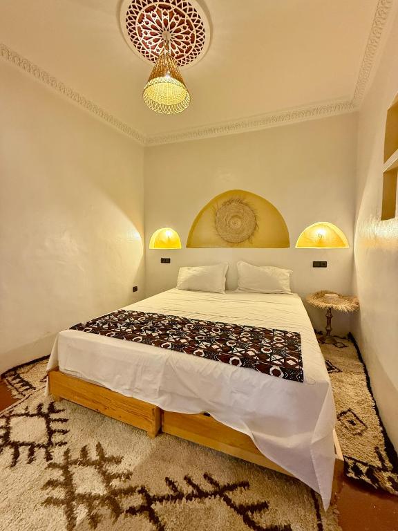 a bedroom with a bed and a chandelier at Dar Zagora Oasis - Authentic Moroccan Stay in Zagora