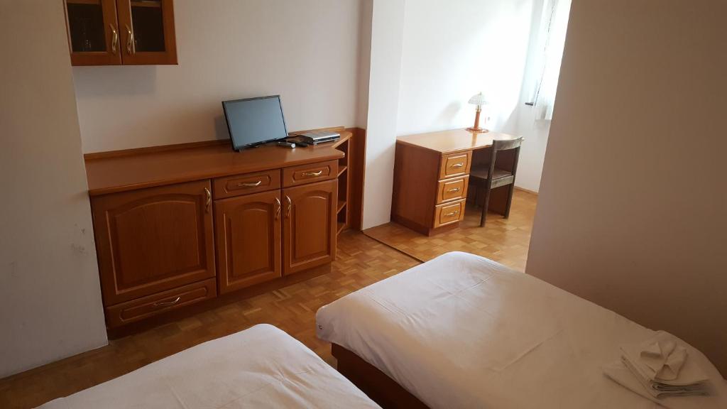 een kamer met 2 bedden en een bureau met een computer. bij Marinčič Inn in Škocjan